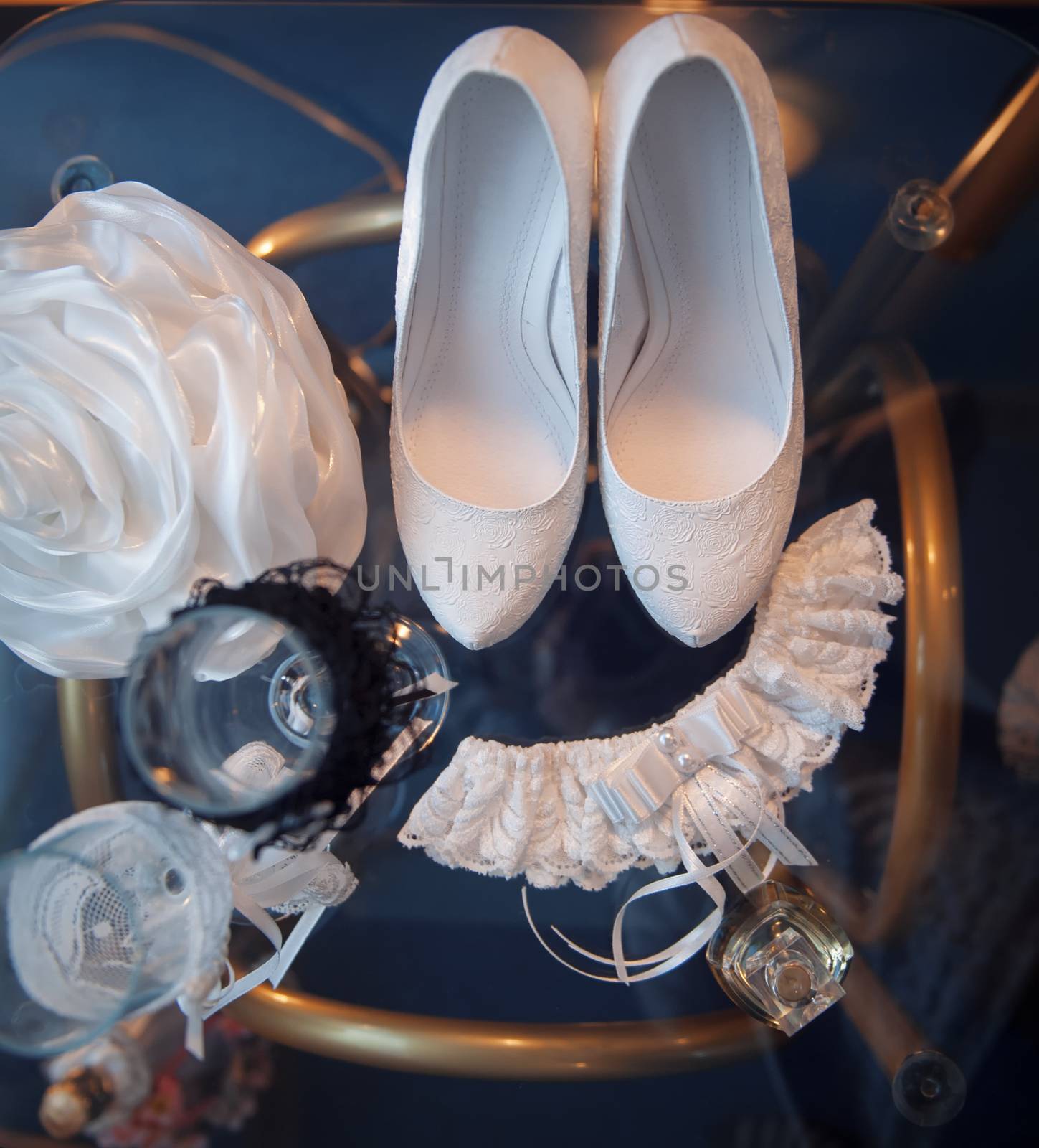 white bridal shoes and other wedding attributes on a table