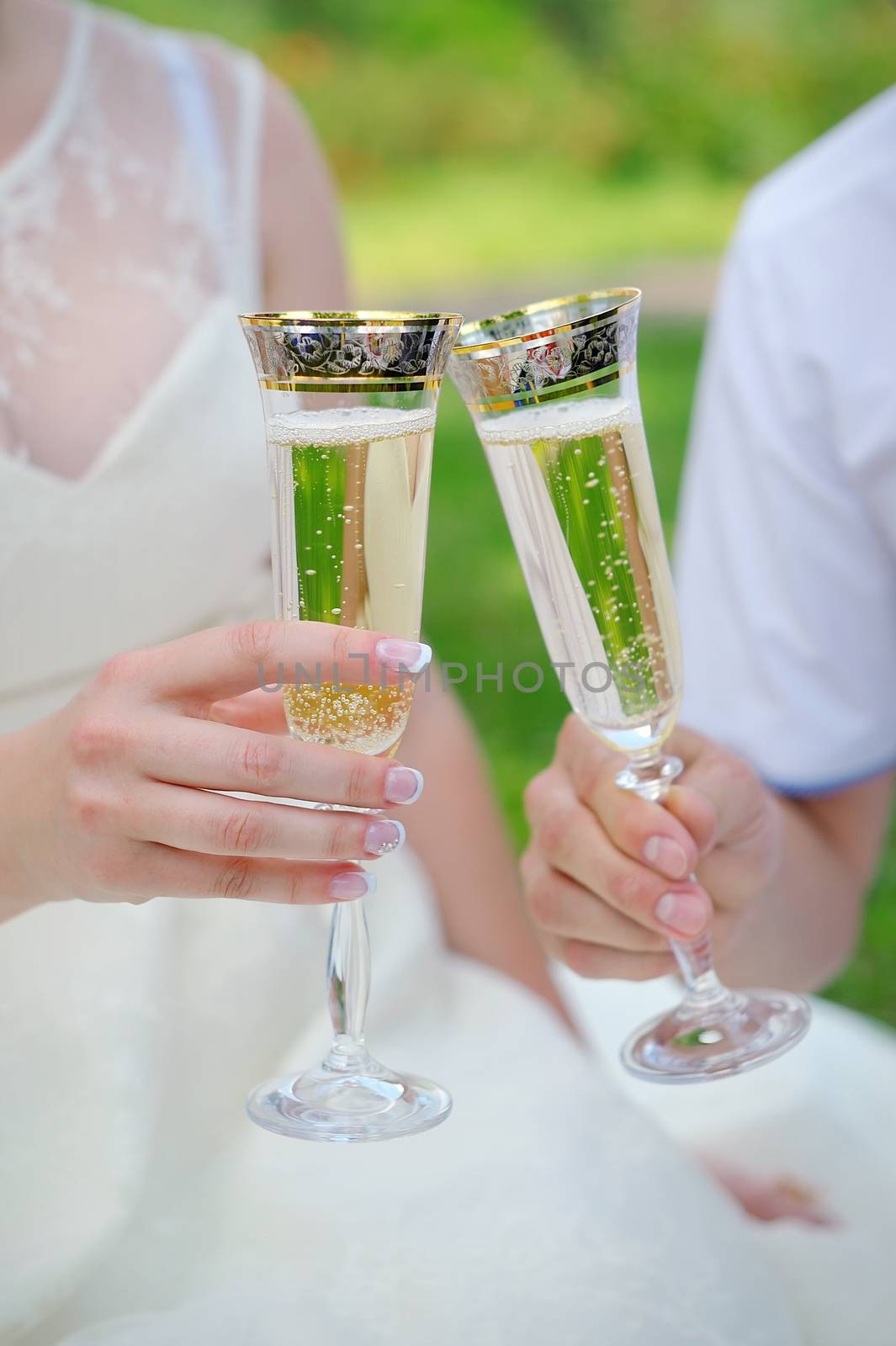 hand the bride and groom with glasses of champagne