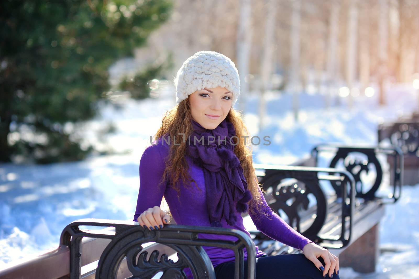 Beautiful and sexy woman sitting on bench in winter