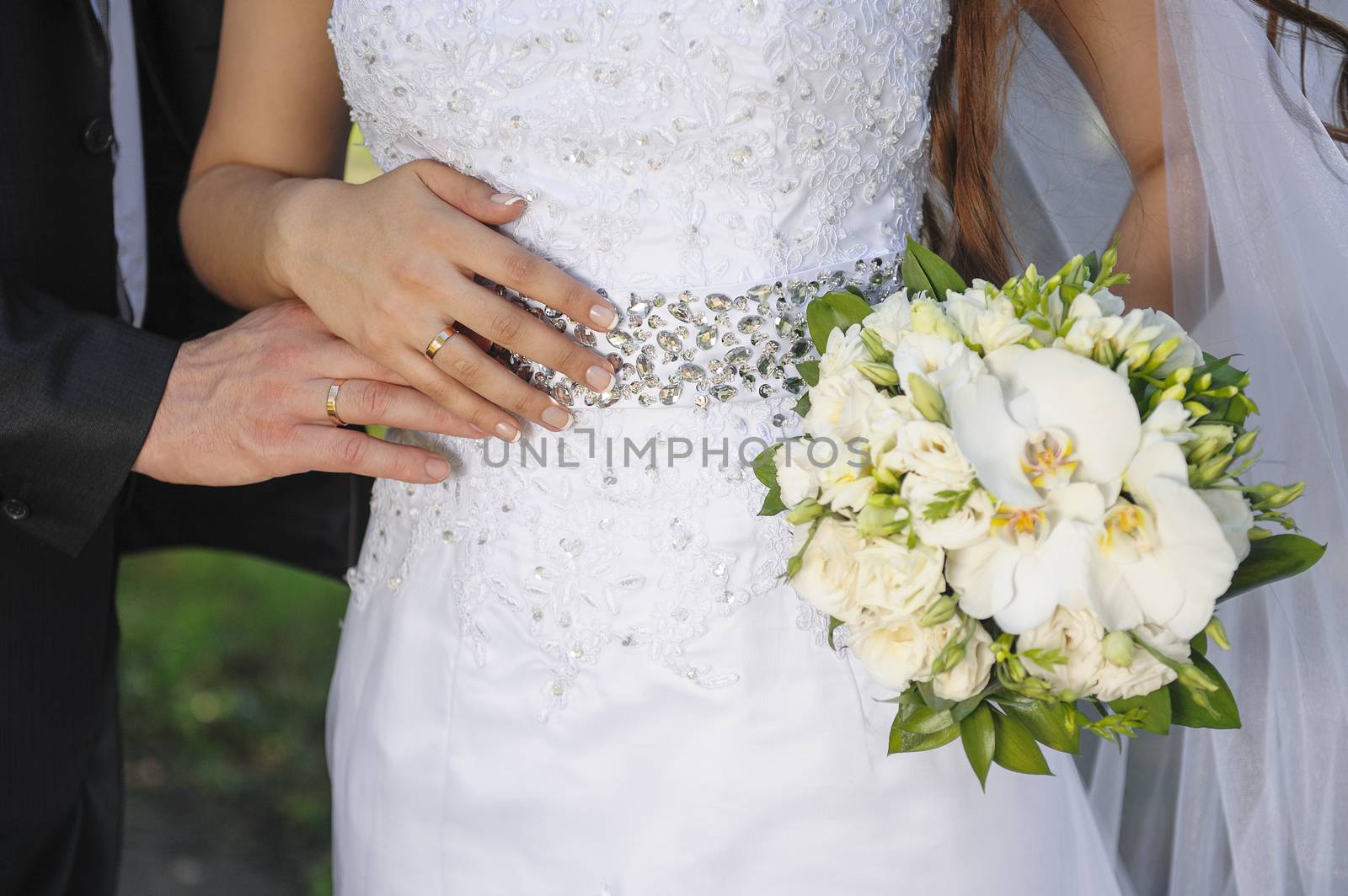 Bride holding white wedding bouquet of roses and love flower