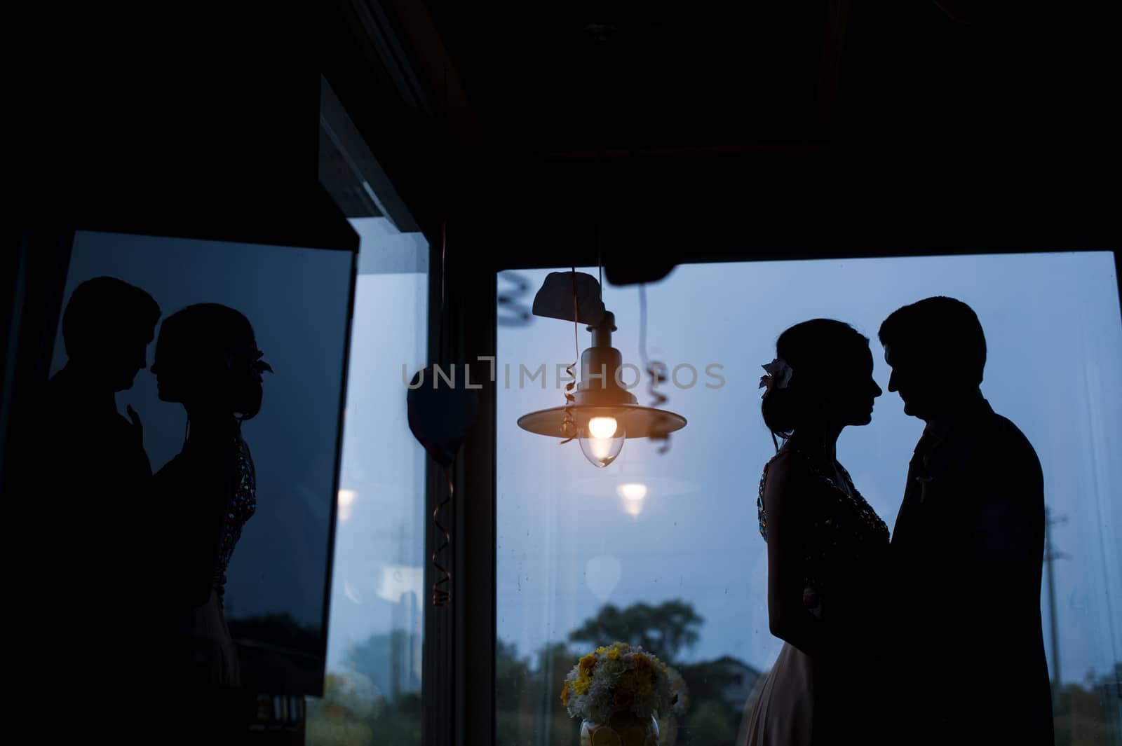 silhouettes of the bride and groom on the background of the window