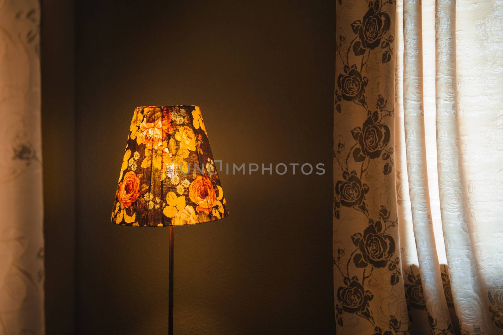 vintage Bedroom floor lamp glowing orange in a corner of a room 