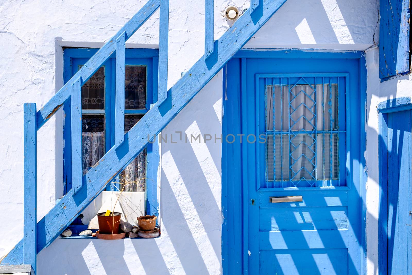 Detail of typical traditional doors and windows in white and blue style, Plaka village on Milos island, Greece