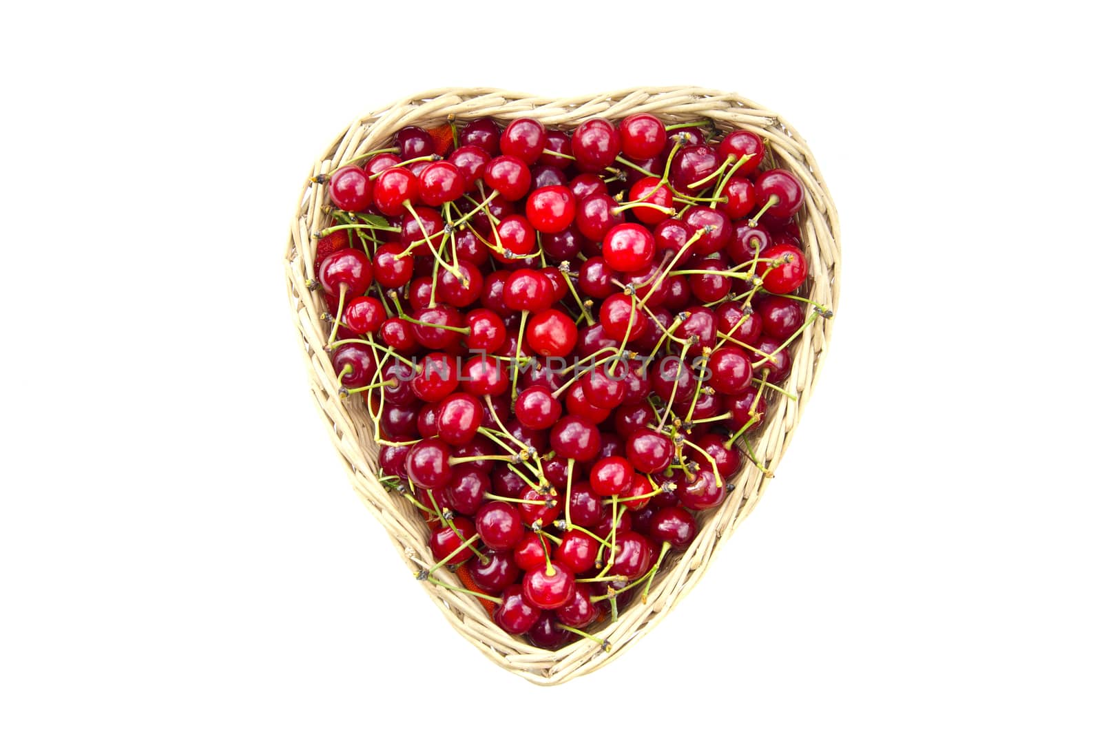 Ripe sweet cherries in heart shaped wicker basket isolated on white