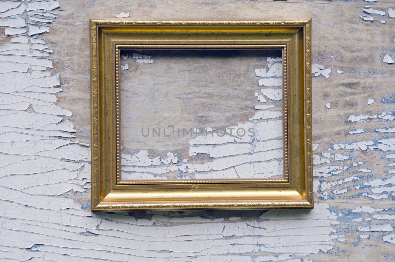 Empty golden frame placed on background with peeling paints