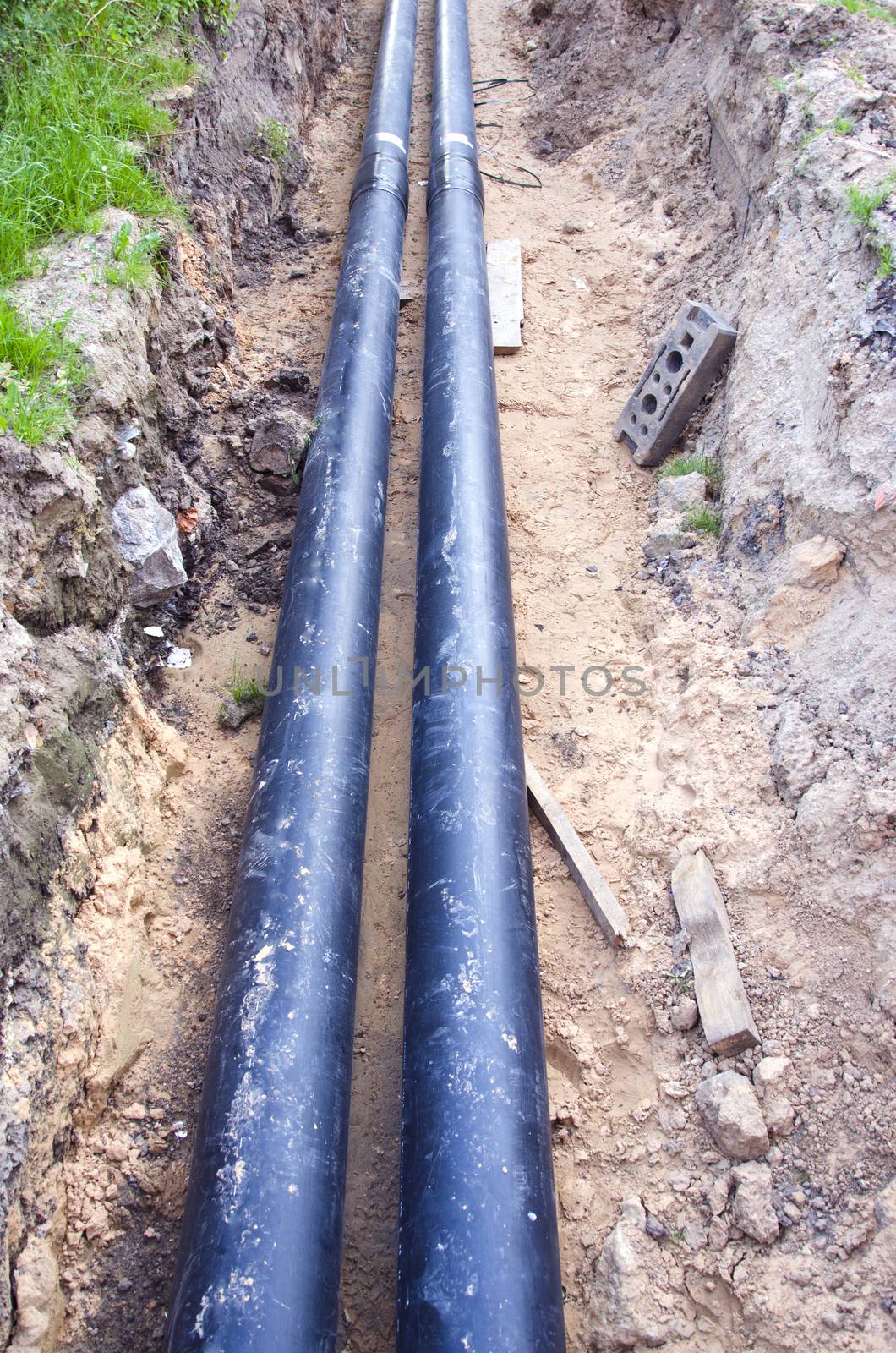 Two new black waterpipes in a ditch  