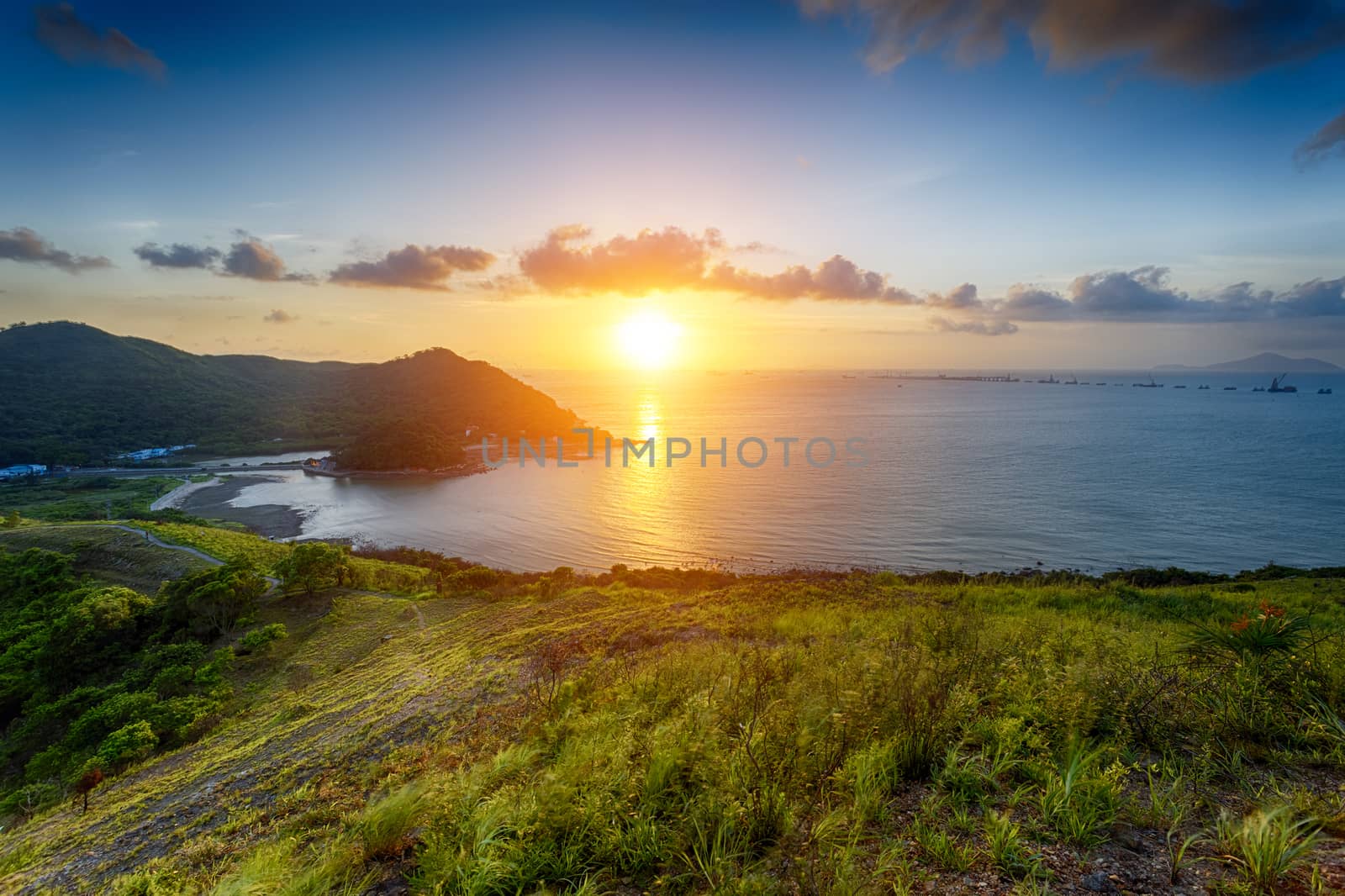 Village with beautiful sunset over hong kong coastline by cozyta