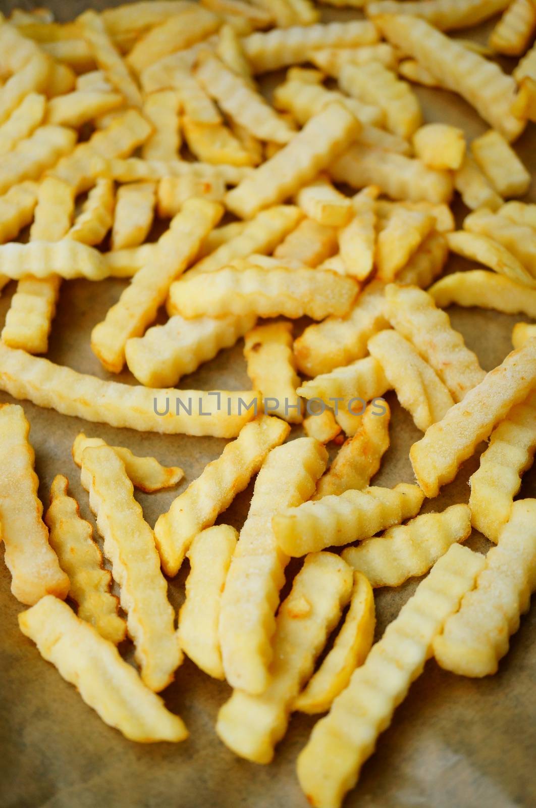 Frozen potato fries on paper