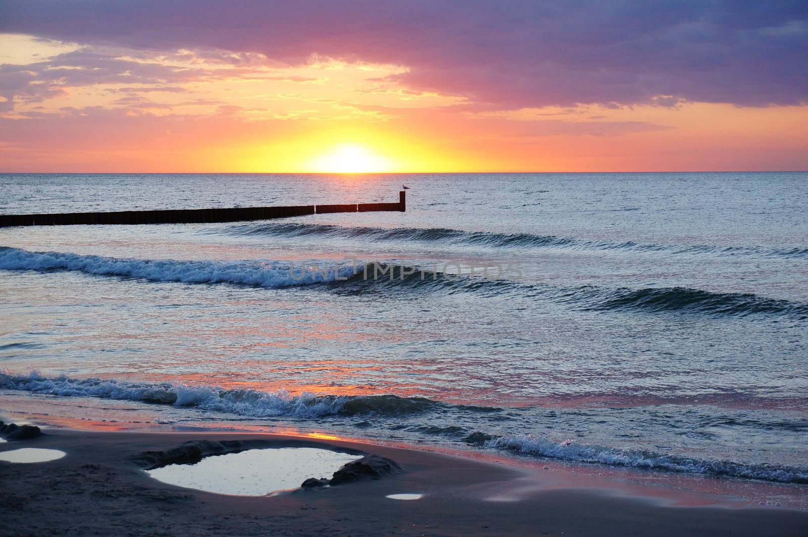 Sand beach by coast by sunset in the evening