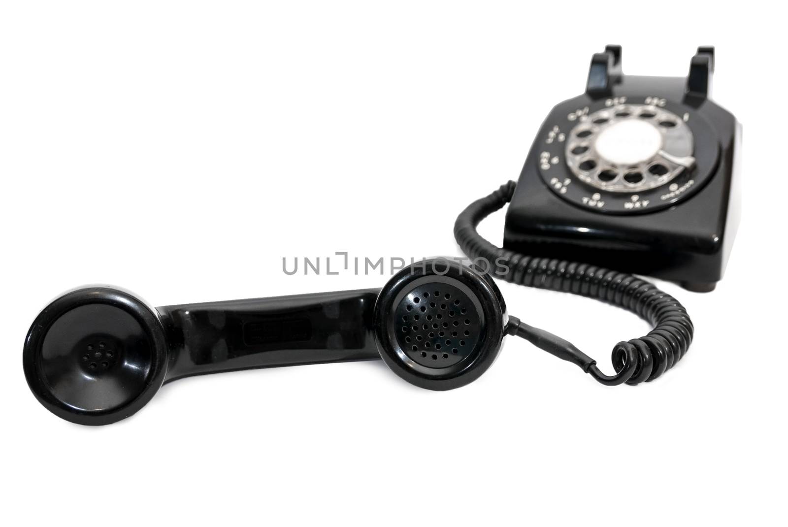 Black Rotary Dial Telephone With Receiver In Focus And Phone Blurred in Background by stockbuster1