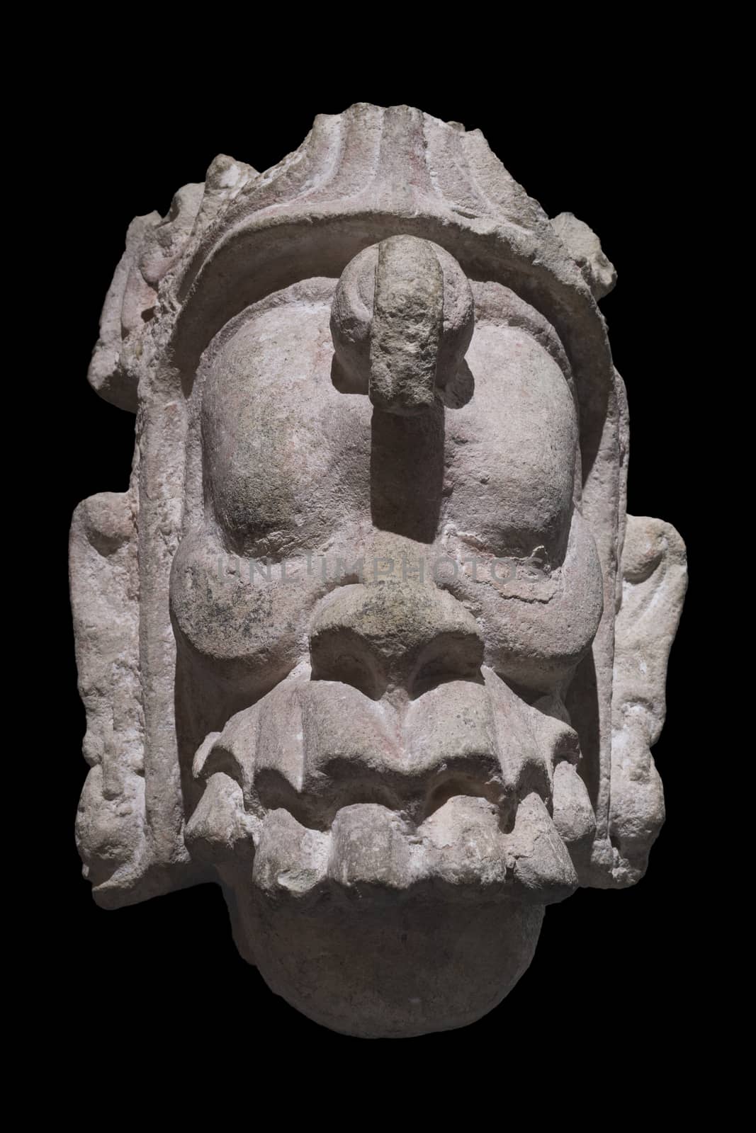 Closeup stone Mayan sculpture of head of supernatural being from Copan, Honduras isolated on black background