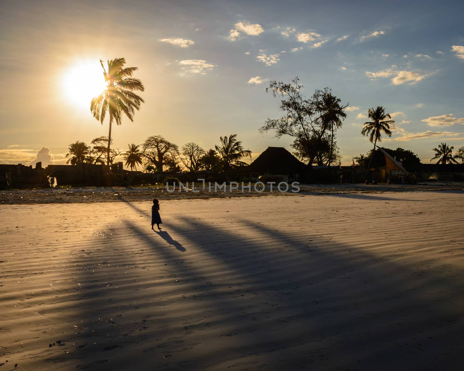 a nice view of alone kid in zanzibar island at sunset.