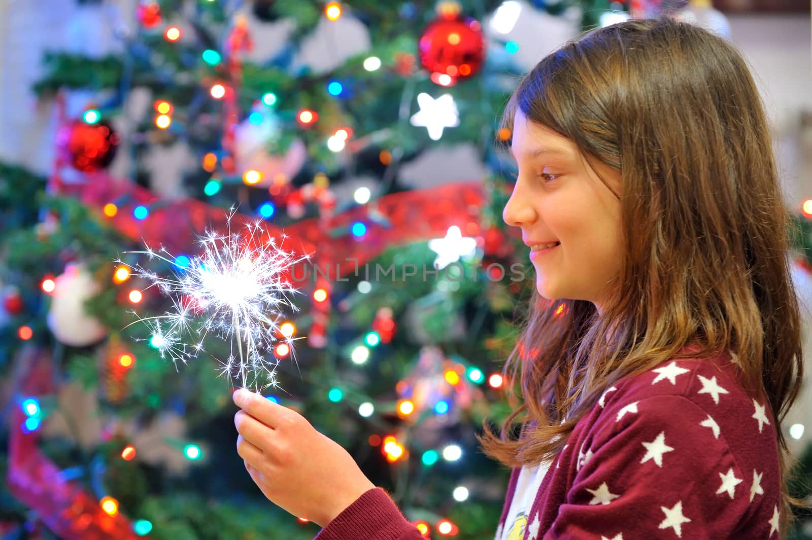 Portrait of cute girl looking at festive fire sparks.
