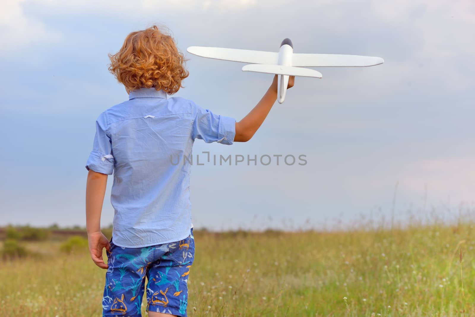Boy with toy plane on field