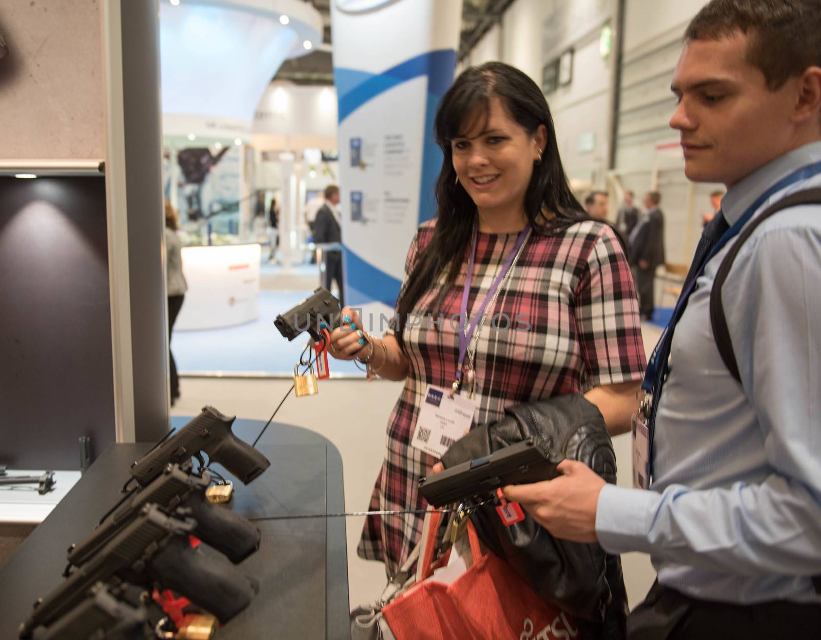 UNITED KINGDOM, London: Visitors inspecting pistols	The Defence and Security International Exhibition (DSEI) began in London on September 15, 2015 despite a week of direct action protests by peace campaigners.  	The arms fair has seen over 30,000 people descend on London to see the 1,500 exhibitors who are displaying weapons of war from pistols and rifles up to tanks, assault helicopters and warships.  	Protesters attempted to block the main road into the exhibition, claiming that such an event strengthened the UK's ties to human rights abuses. 