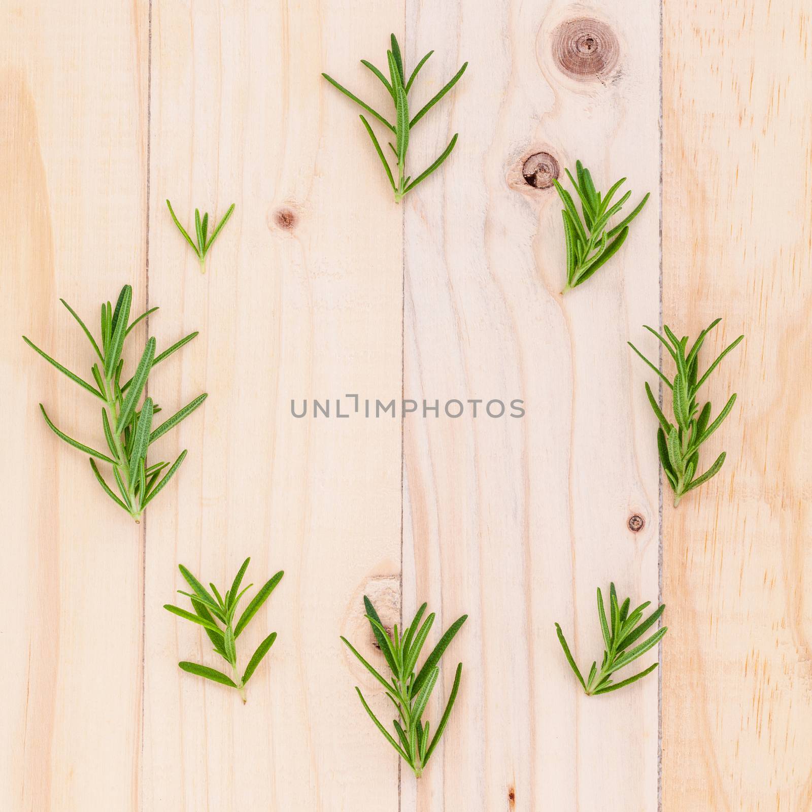 The circle of  rosemary leaf on wooden background for menu design and advertising campaign.