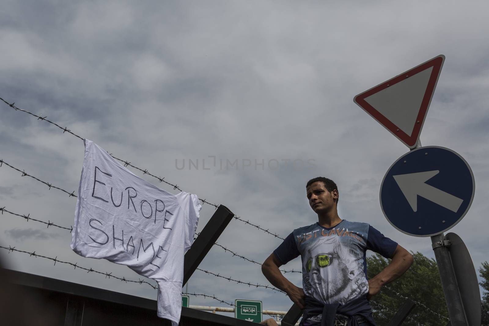 SERBIA, Horgos: A refugee stands beside a sign that reads EUROPE SHAME at the Serbia-Hungary border, after Hungary closed the border crossing on September 16, 2015.****Restriction: Photo is not to be sold in Russia or Asia****