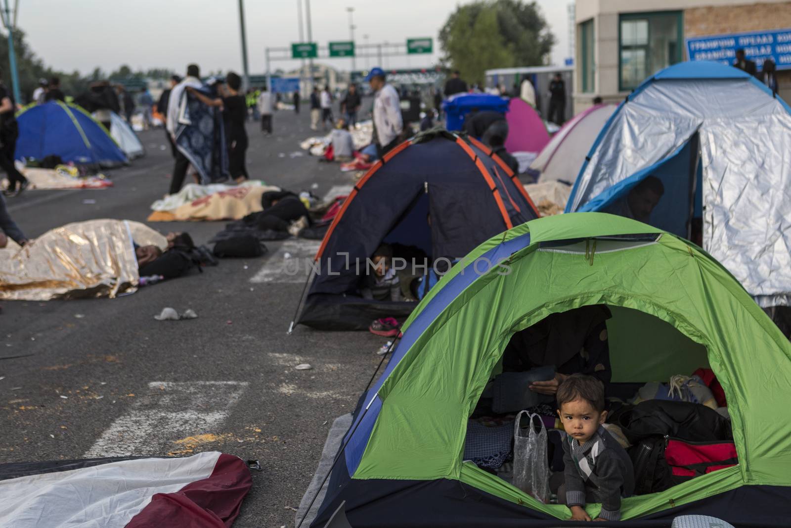 SERBIA, Horgos: A child refugee peers out a tent at the Serbia-Hungary border, after Hungary closed the border crossing on September 16, 2015.****Restriction: Photo is not to be sold in Russia or Asia****