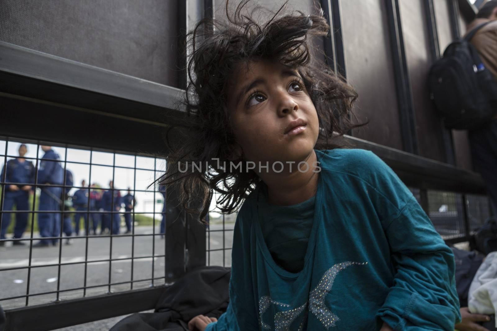 SERBIA, Horgos: A refugee child wakes up behind a border fence as Hungarian border guards appear in the background at the Serbia-Hungary border after Hungary closed the border crossing on September 16, 2015.****Restriction: Photo is not to be sold in Russia or Asia****