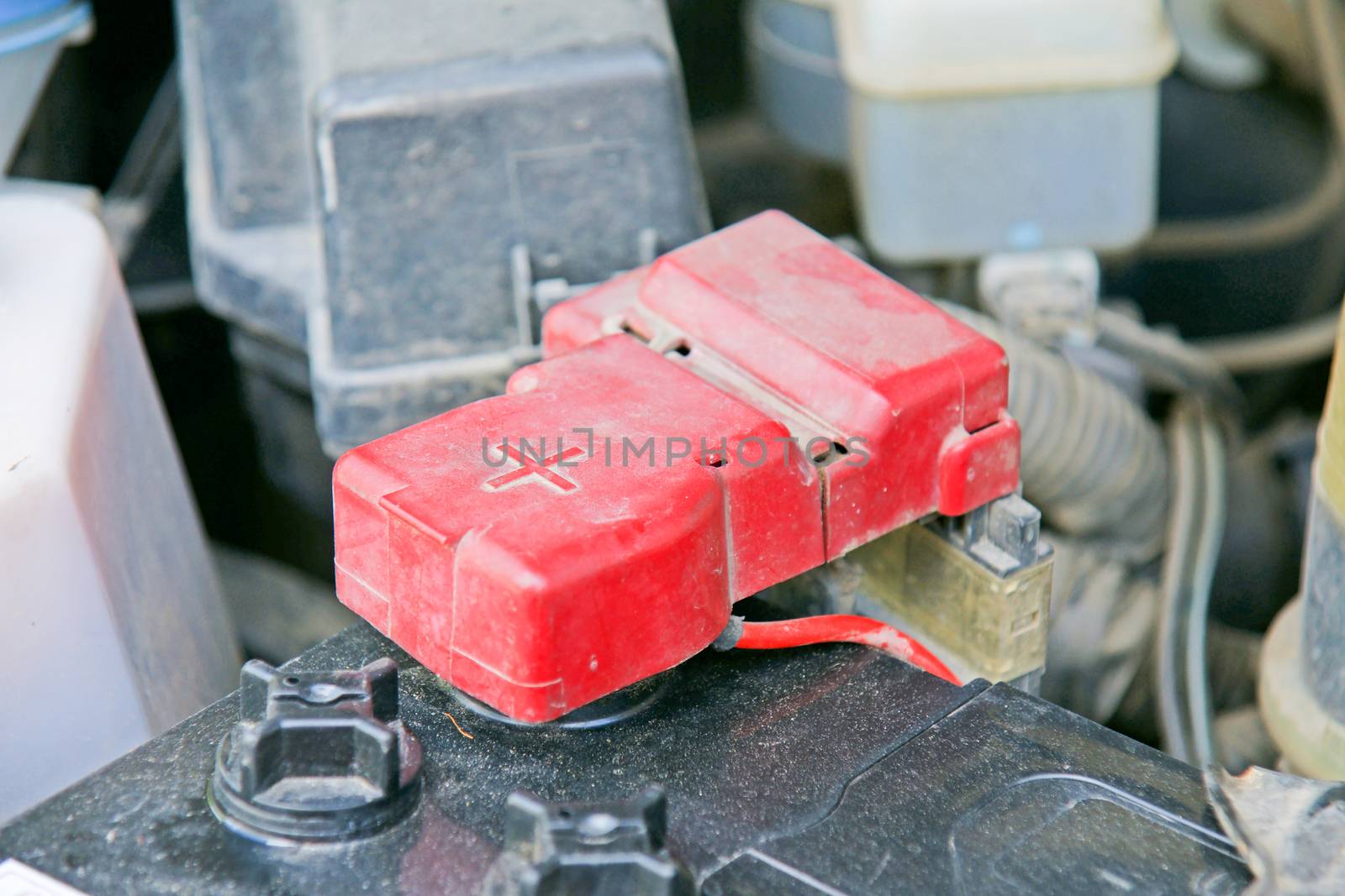 Car battery with red positive polarity for auto concept (Selective focus at positive symbol)