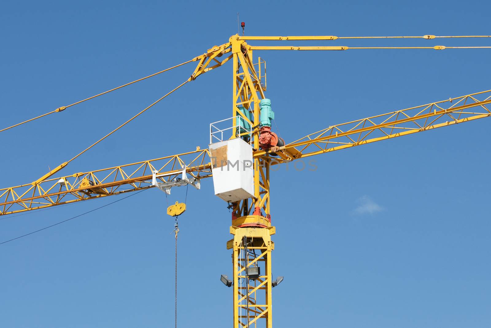 Yellow Industrial crane and blue sky on construction site or seaport by mranucha