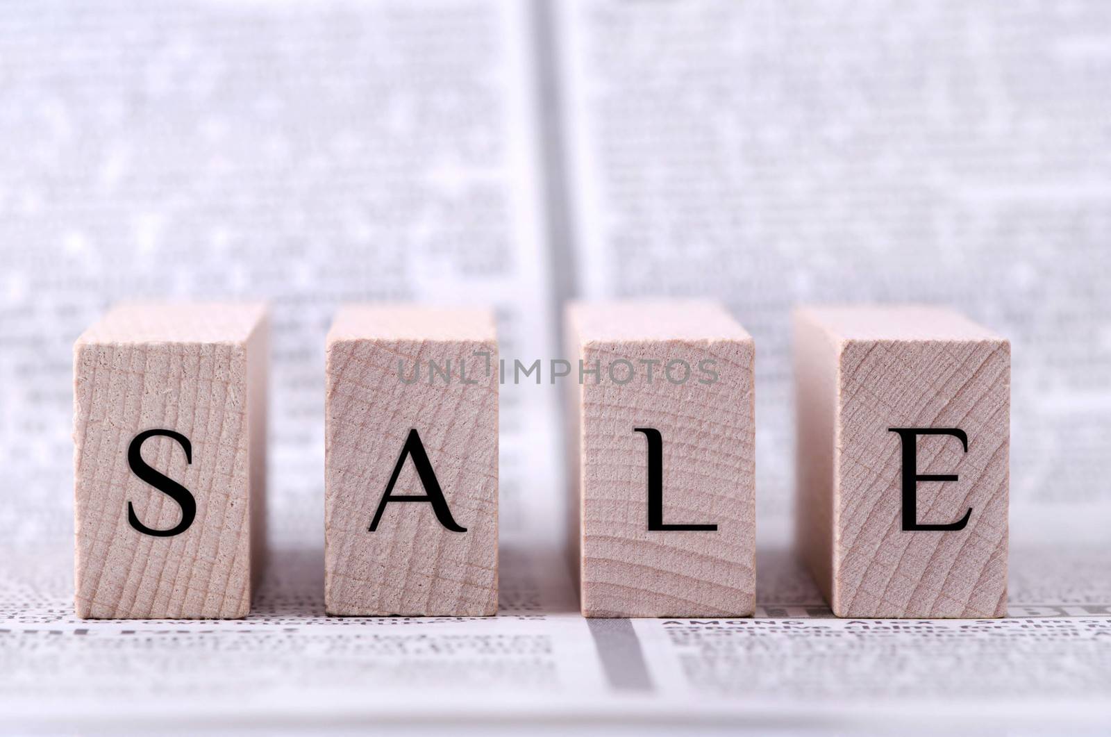 Four wooden blocks with word sale written on.