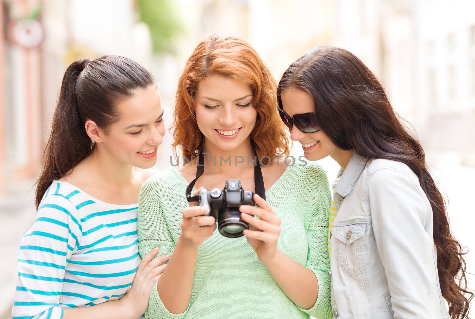 smiling teenage girls with camera by dolgachov