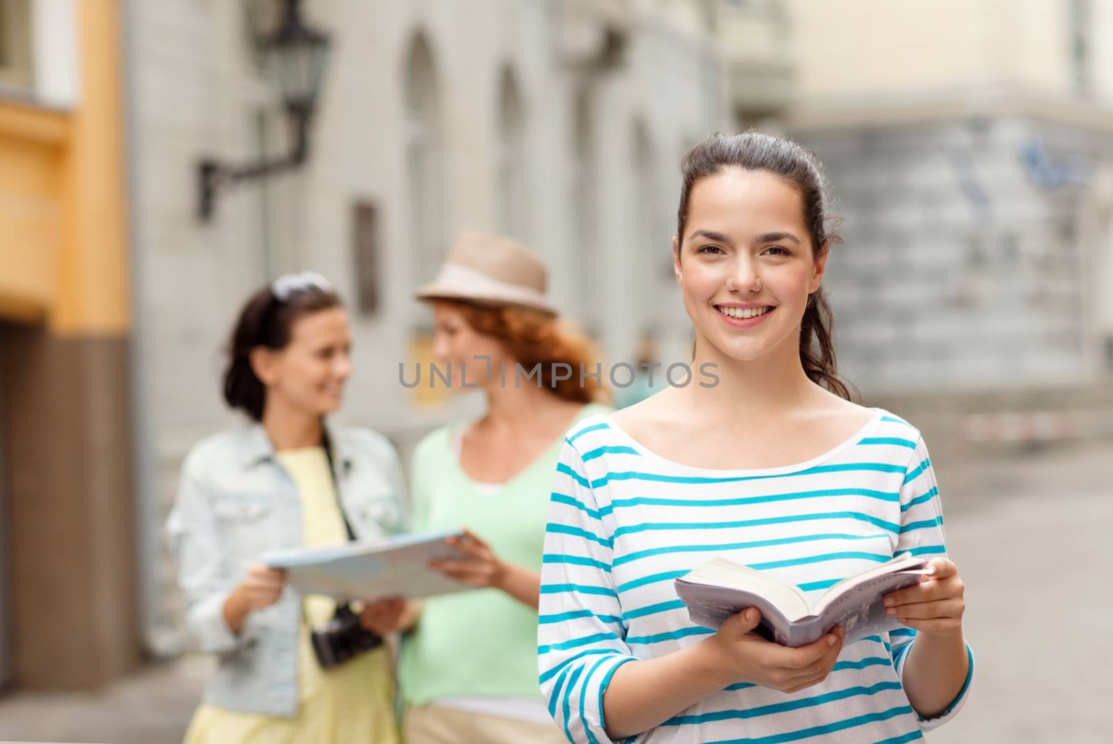 tourism, travel, holidays and friendship concept - smiling teenage girls with city guide, map and camera outdoors