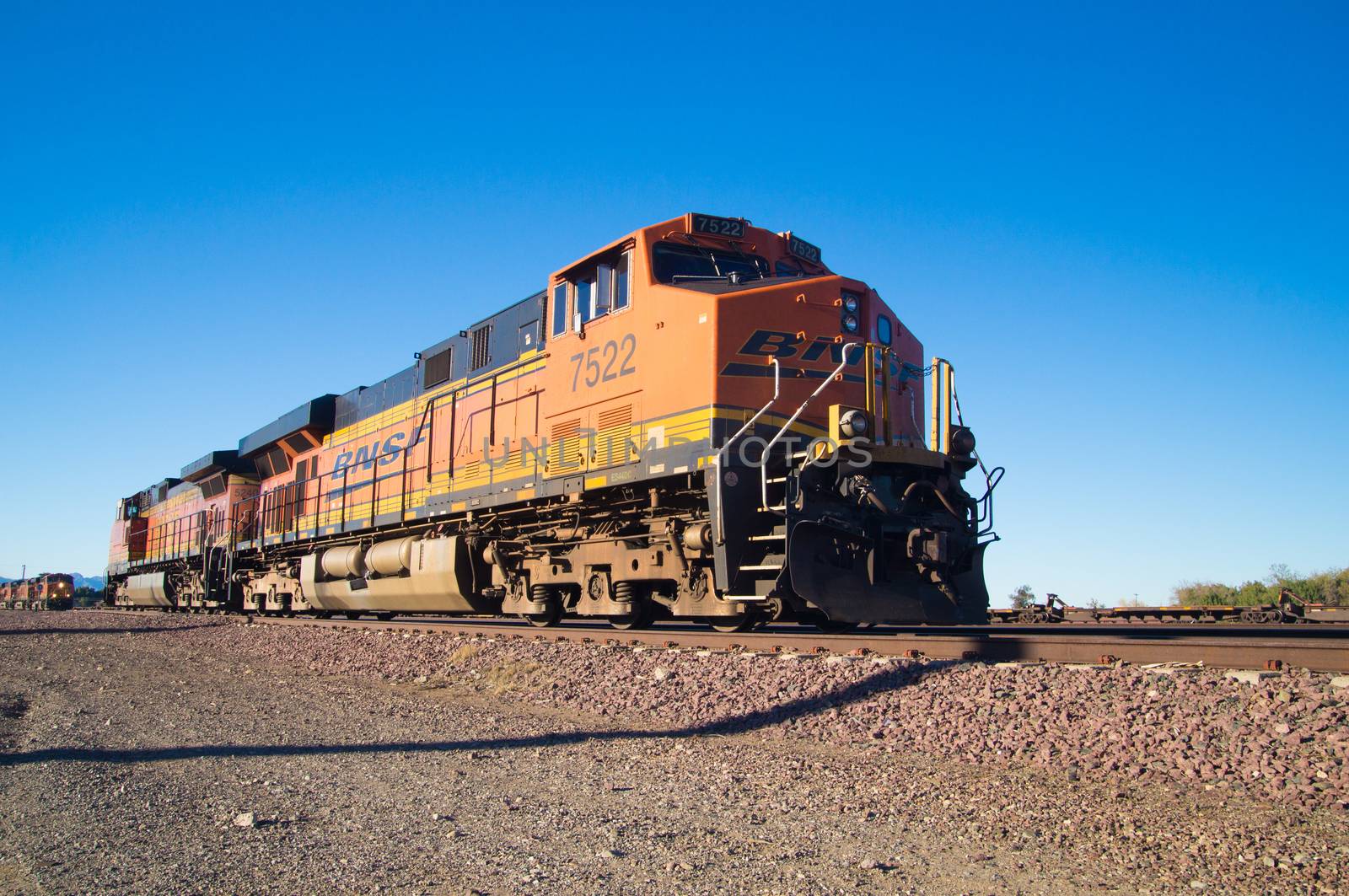 Distinctive orange and yellow Burlington Northern Santa Fe Locomotive freight train No. 7522 on the tracks at the town of Needles, California. Photo taken on February 5 2013.