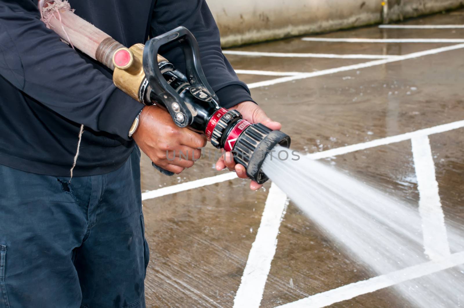 Hand of Firefighter at works with water cannon