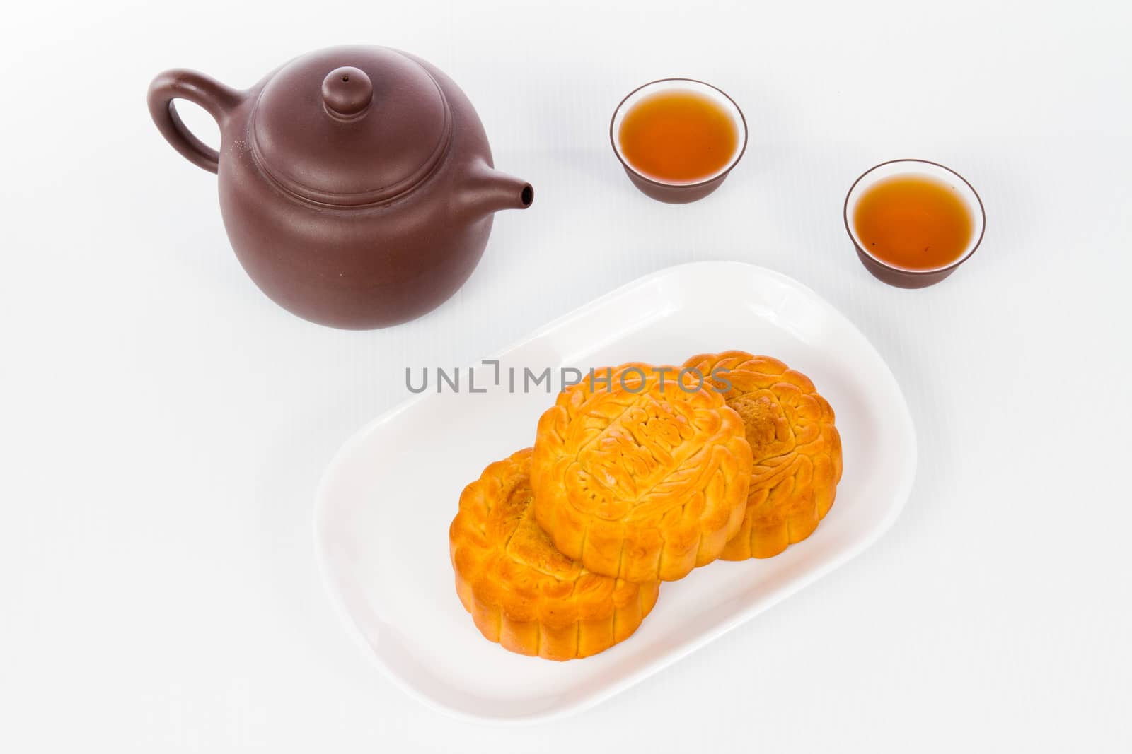 Chinese mid autumn festival with moon cake and tea pot setup in plain white background.