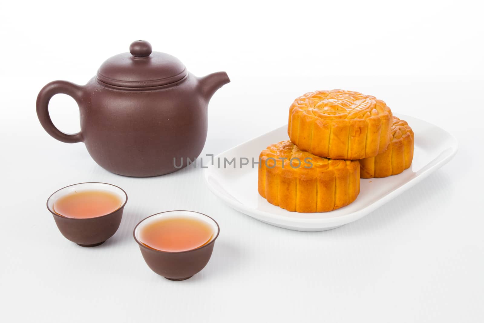 Chinese mid autumn festival with moon cake and tea pot setup in plain white background.