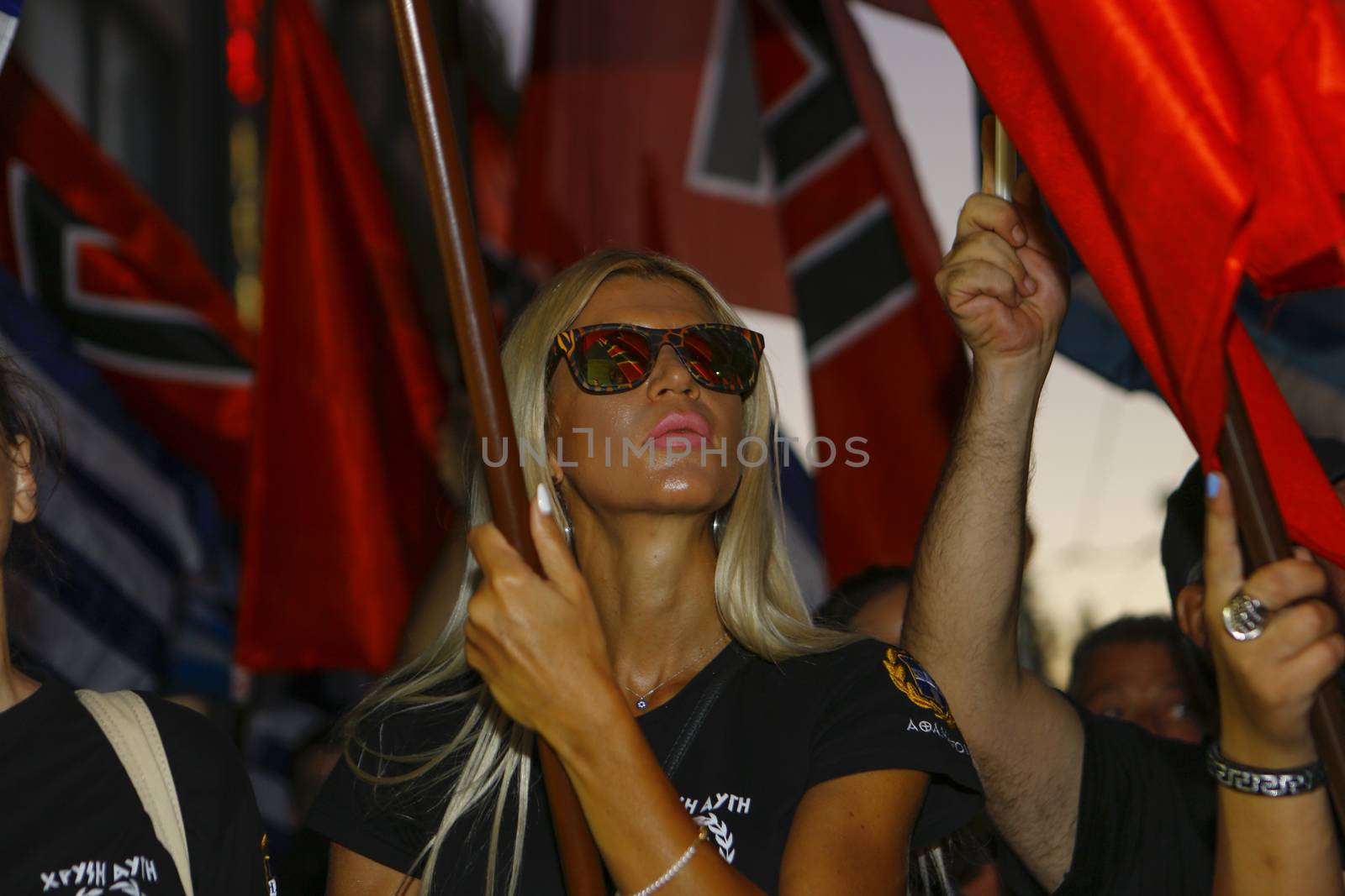 GREECE, Athens: A woman holds a flag as Greece's far-right Golden Dawn party holds an election rally in Athens on September 16, 2015, four days ahead of the country's snap national election. 