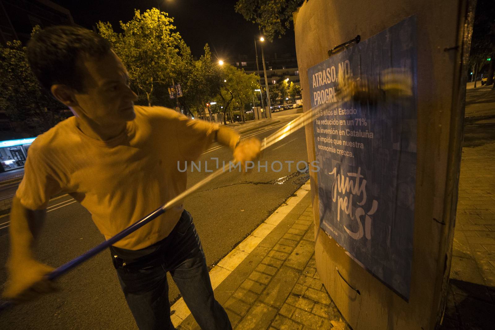 SPAIN, Barcelona: An activist from the pro-independence coalition Junts pel Si (Together for Yes) sticks up posters around Barcelona on the evening of September 16, 2015. Pro-independence groups are rallying their supporters ahead of the Catalonian parliamentary election, taking place on September 27.