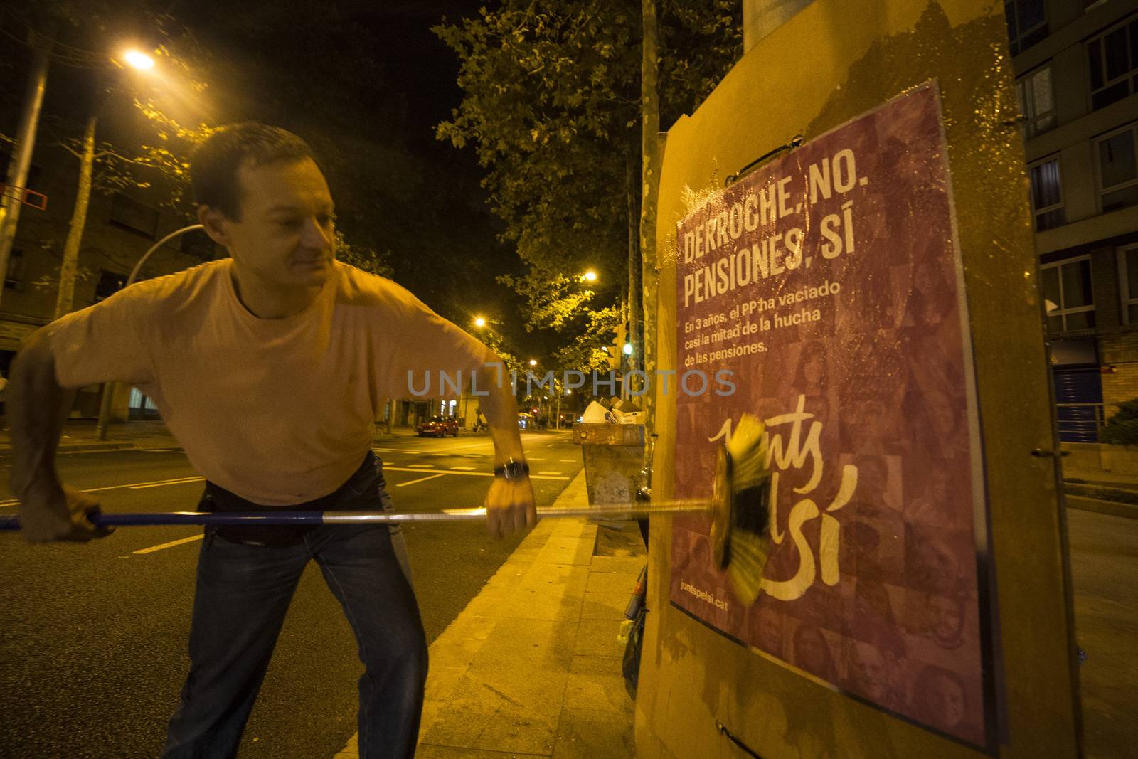 SPAIN, Barcelona: An activist from the pro-independence coalition Junts pel Si (Together for Yes) sticks up posters around Barcelona on the evening of September 16, 2015. Pro-independence groups are rallying their supporters ahead of the Catalonian parliamentary election, taking place on September 27.