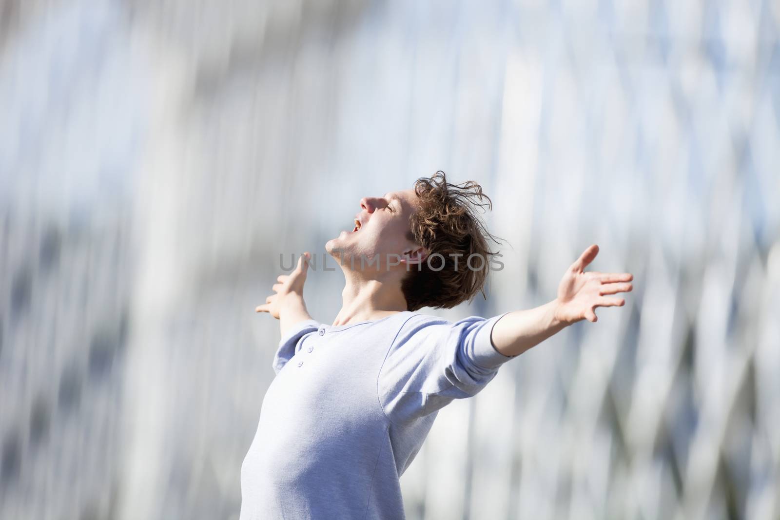 Excited Young Man Stretching out his Arm in Emotion Outdoors