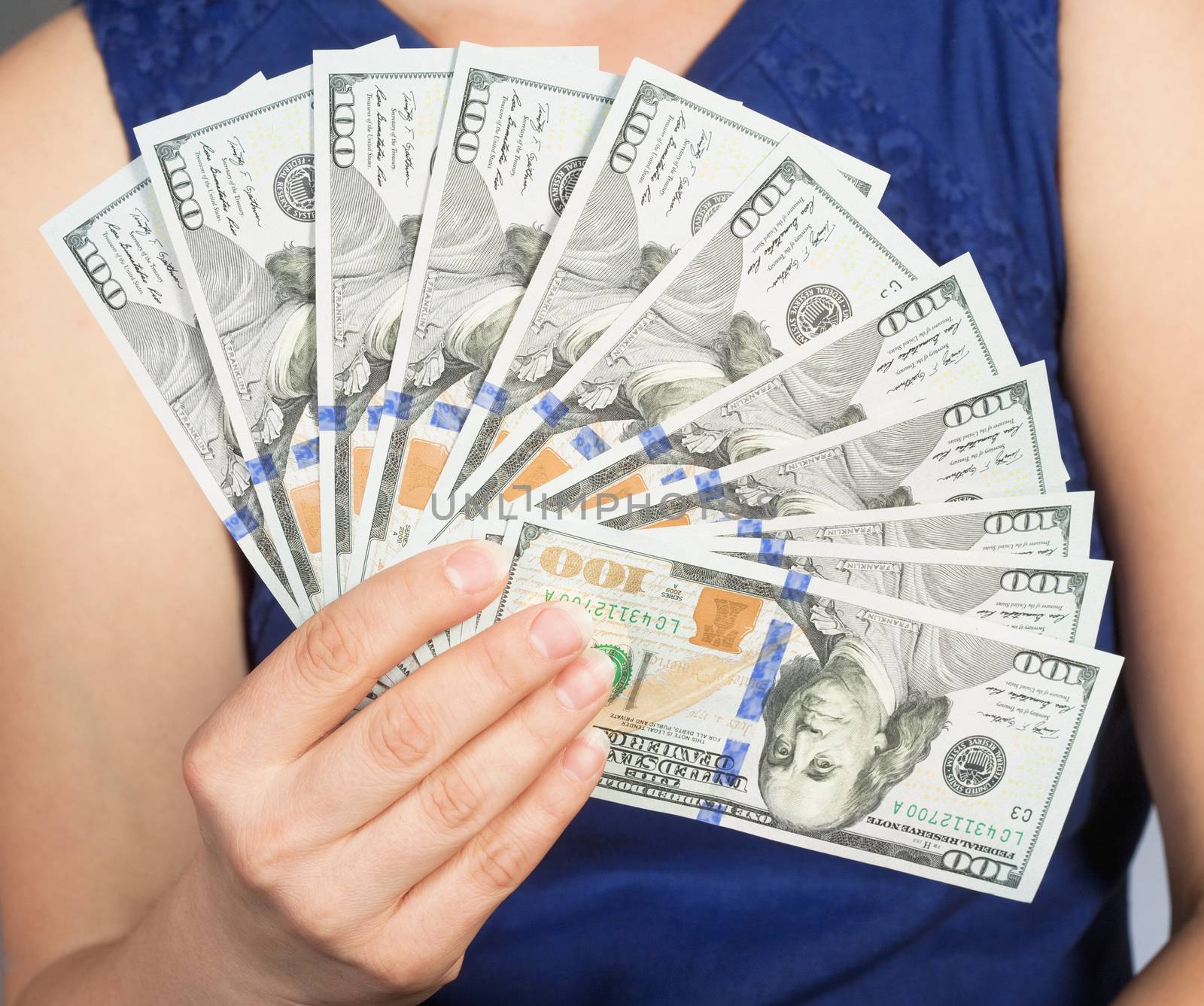 Woman in Blue Dress Holding New 100 US Dollar Bills