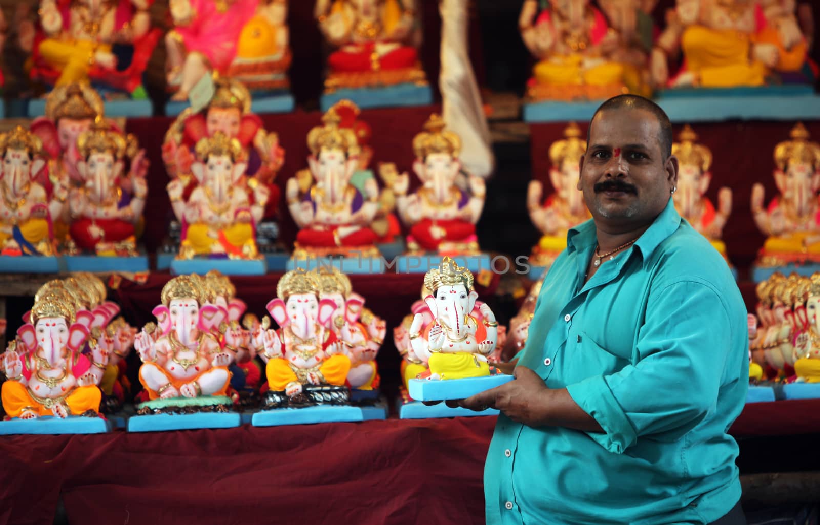 A man selling Lord Ganesh idols on the eve of Ganesh festival in India. The festival involves thousands of visitors from all over the world every year, in the main celebration city - Pune. 