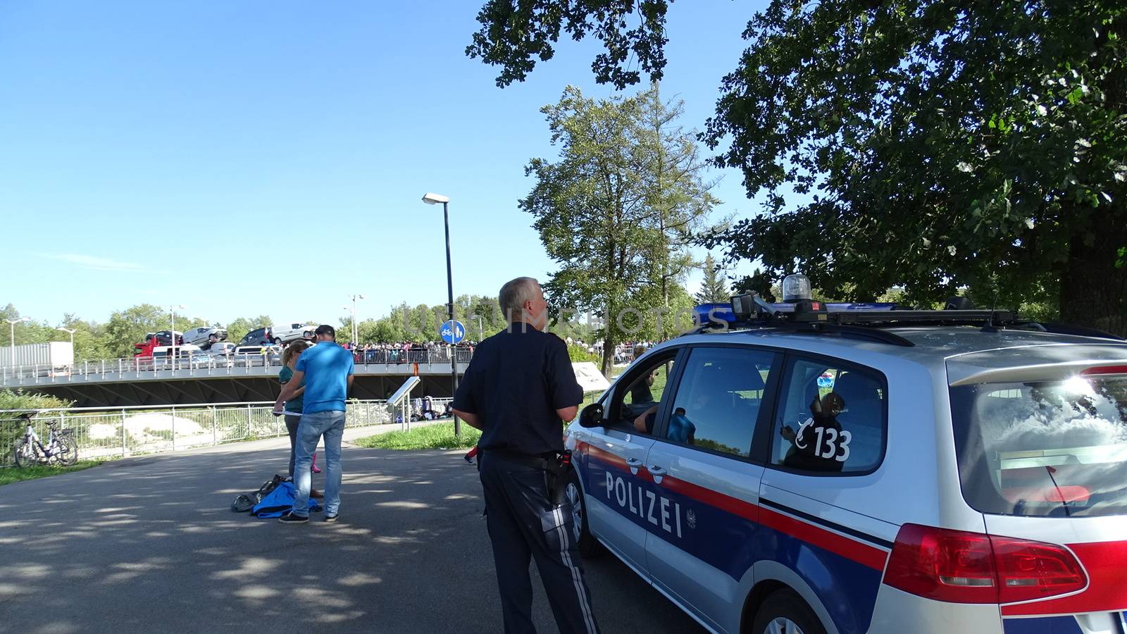 GERMANY, Freilassing: A German policeman watches over refugees at the gates of Freilassing, Bavaria, on the German side of the Germany-Austria border, September 17, 2015.