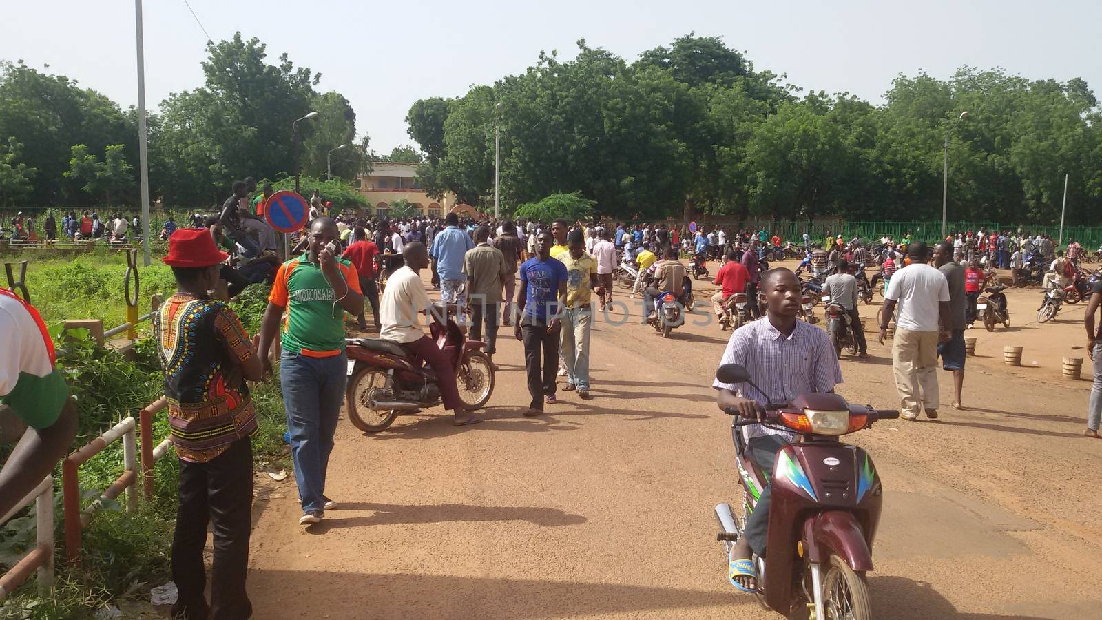 BURKINA FASO, Ouagadougou : Residents rally along a street in Ouagadougou on September 17, 2015, after Burkina Faso's presidential guard declared a coup, a day after seizing the interim president and senior government members, as the country geared up for its first elections since the overthrow of longtime leader Blaise Compaore.