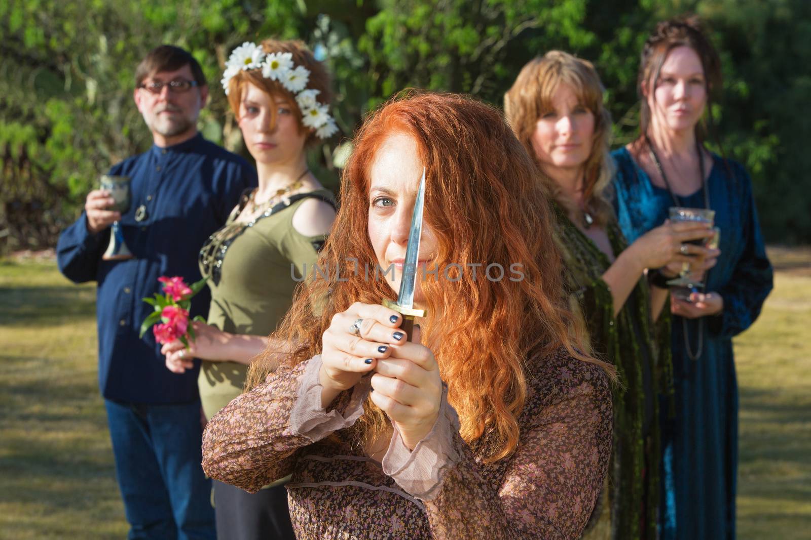 Modern pagan woman standing outdoors with ritual knife