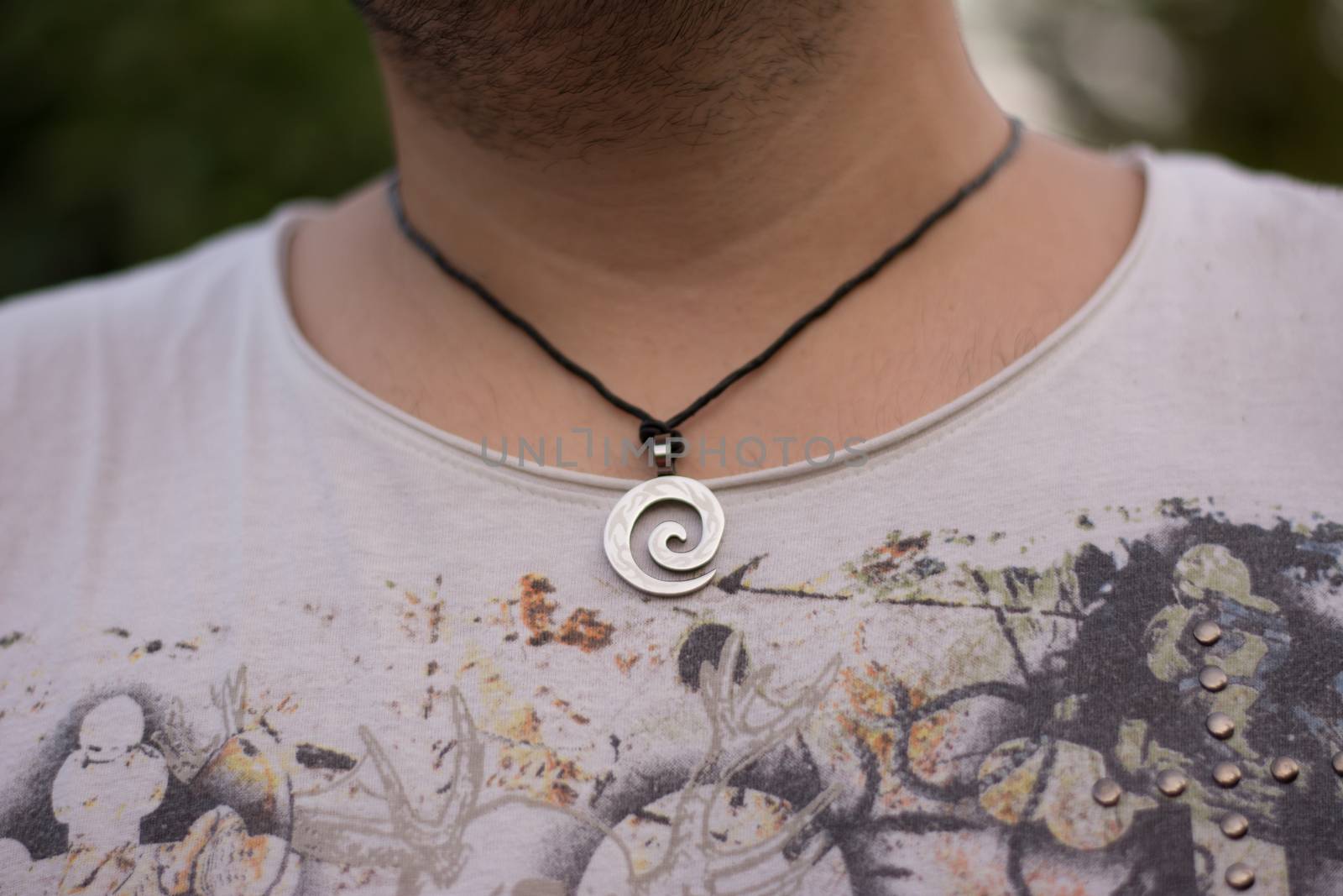 Close up view of a necklace on a man's neck.