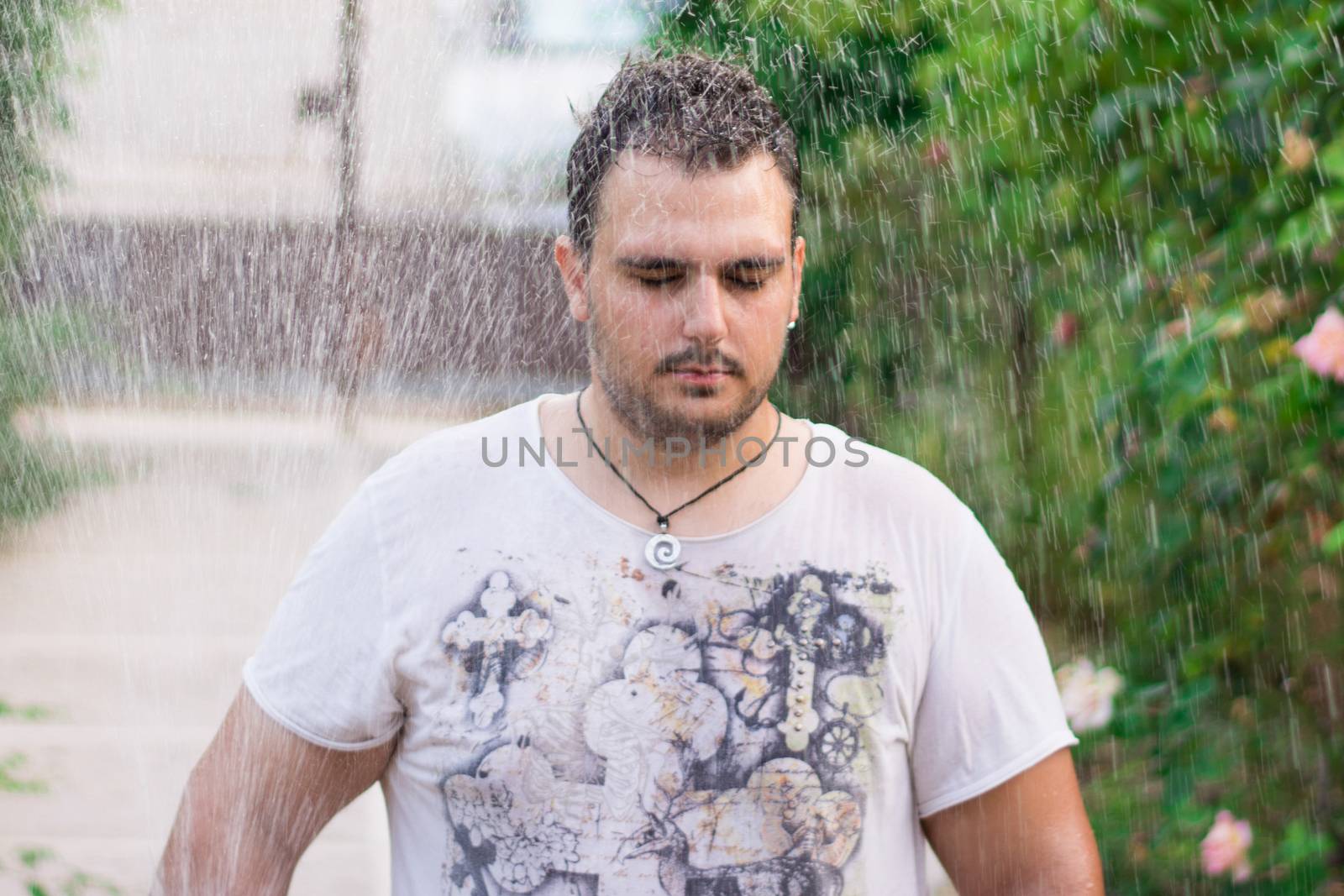 Man standing with his eyes closed in the rain.