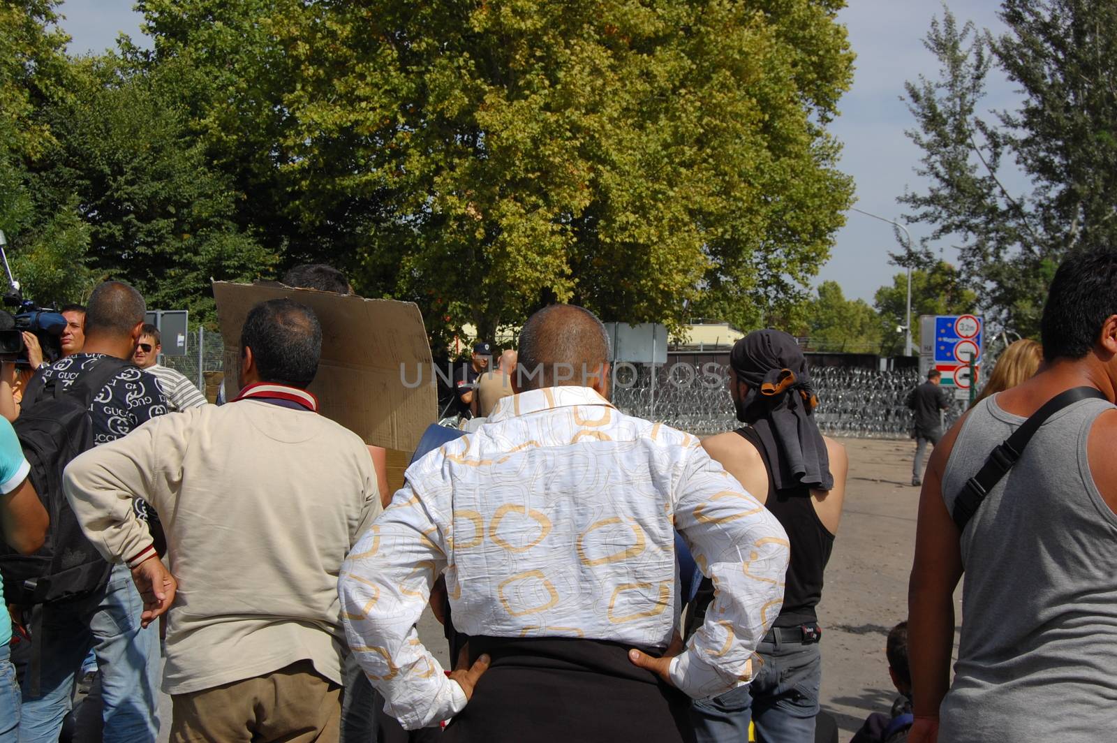 SERBIA, Horgo�: Migrants gather and at a razor-wire fence in Horgo�, Serbia on September 17, 2015. Recently the migrants have clashed with police forcing the police to use tear gas and water cannons to hold the refugees at bay. The migrants demanded that the razor-wire fence be opened, which would allow them to continue their journey though Europe. 