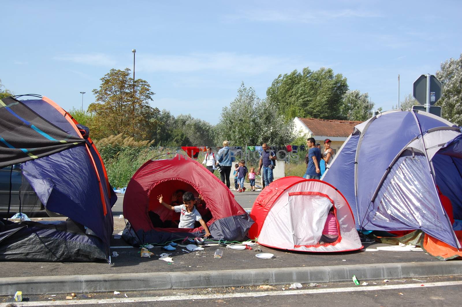 SERBIA, Horgo�: Migrants sit in tents and gather near the Serbia-Hungary border in Horgo�, Serbia on September 17, 2015. Recently the migrants have clashed with police forcing the police to use tear gas and water cannons to hold the refugees at bay. The migrants demanded that the razor-wire fence be opened, which would allow them to continue their journey though Europe. 
