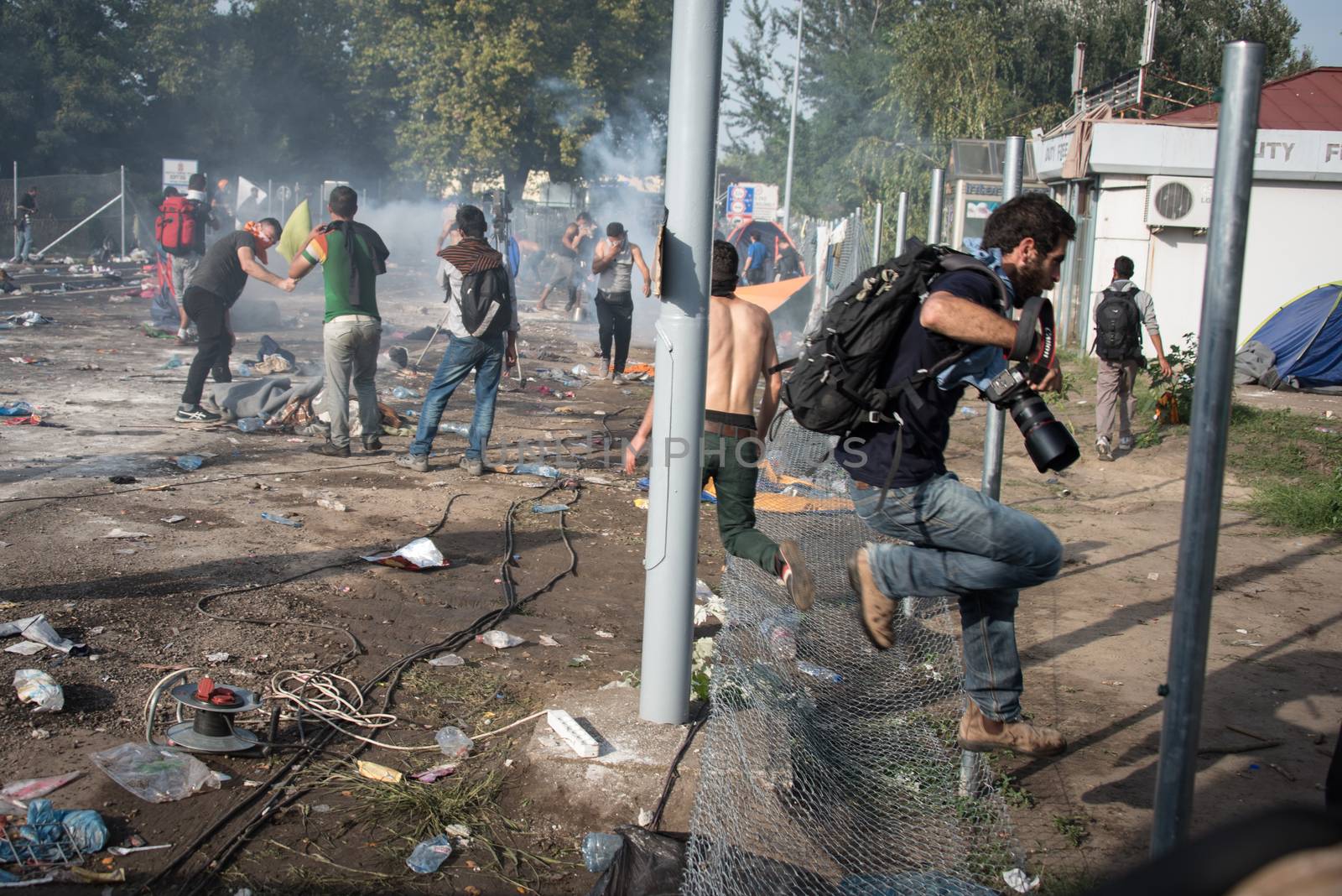 SERBIA, Horgos: A cameraman flees as Hungarian riot police clash with refugees waiting to cross the border from the Serbian border town of Horgos on September 16, 2015. 
