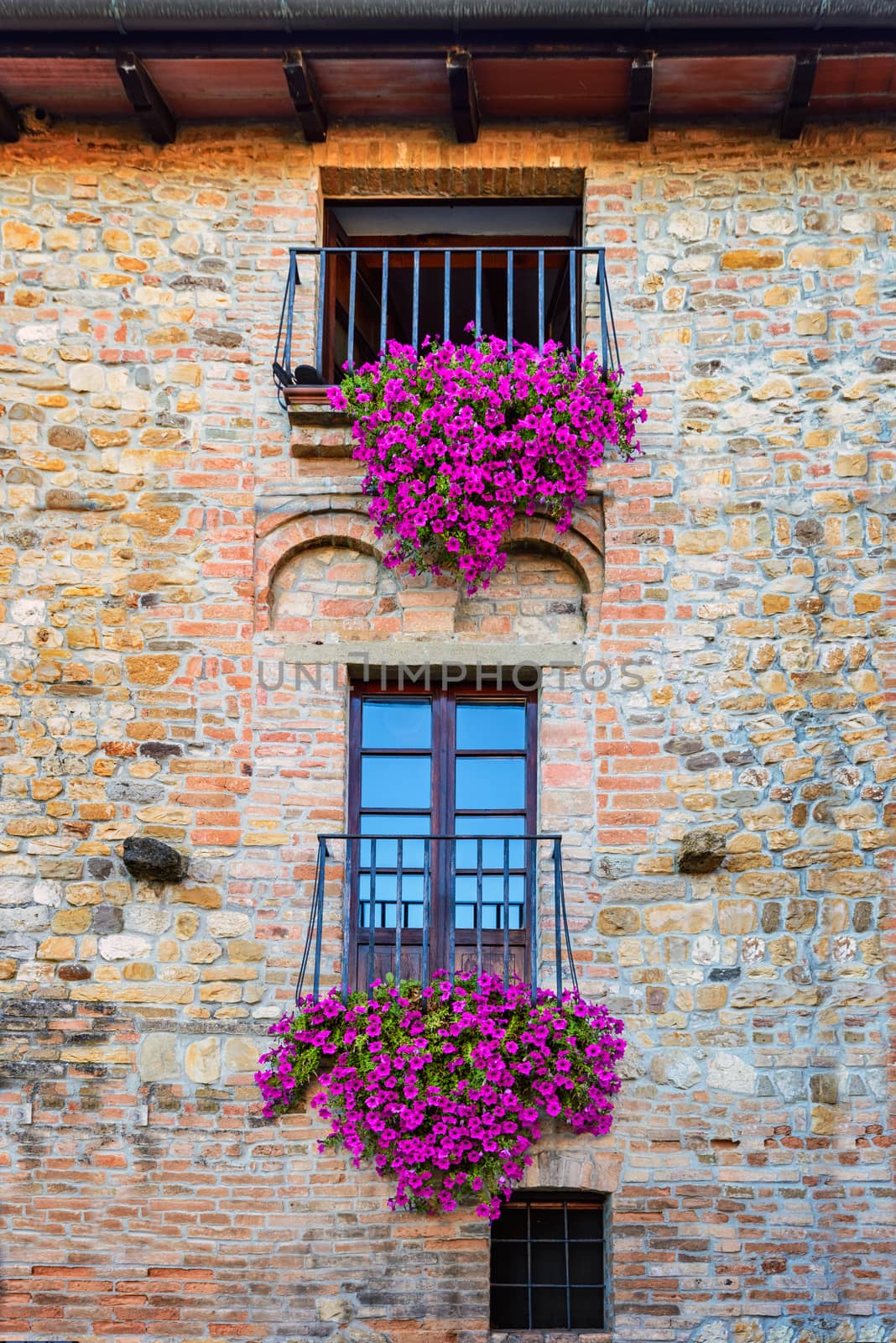 Beautiful vintage balcony with colorful flowers and stone wall medieval , Mediterranean style