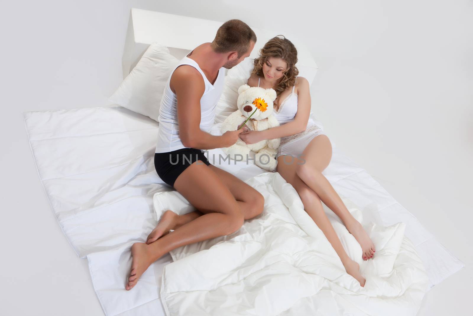 Young beautiful woman and man in lingerie with toys and home accessories