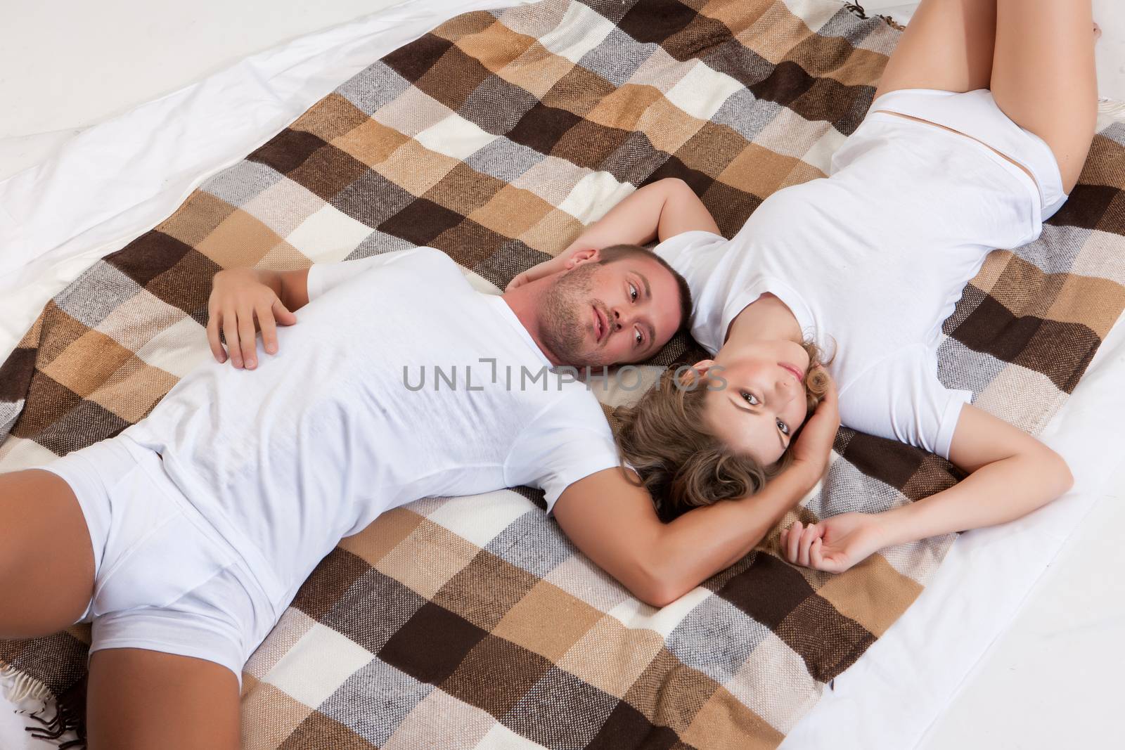 Young beautiful woman and man in lingerie with toys and home accessories