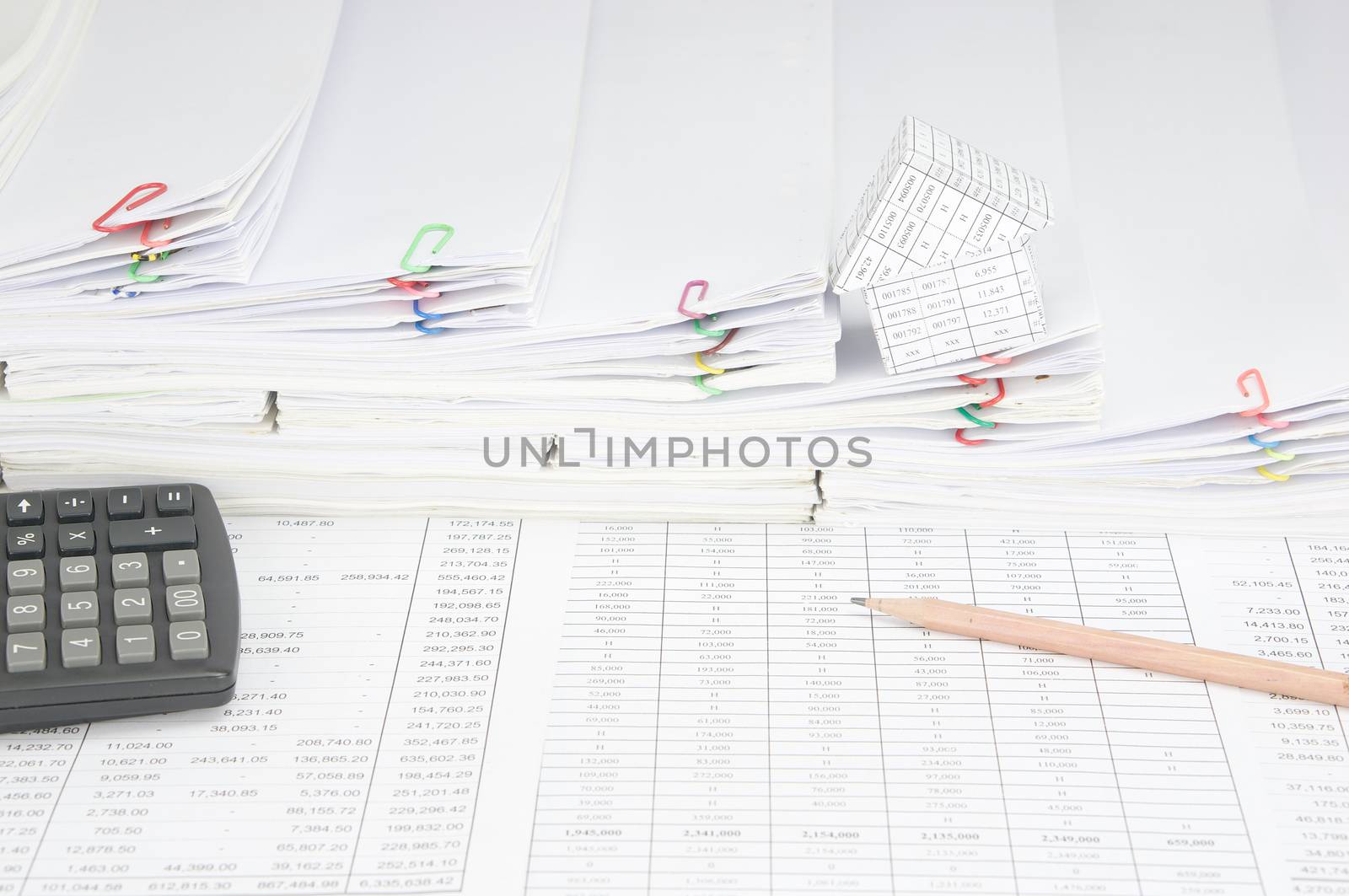 Pencil and calculator on finance account have house on step pile of paperwork as background.